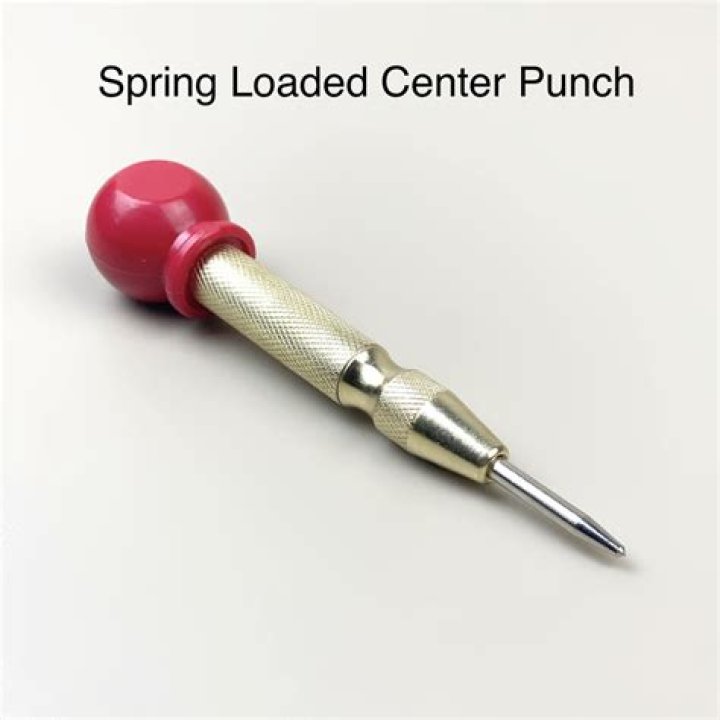 How do spring-loaded center punches work?